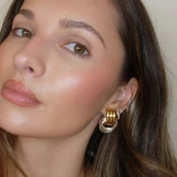 A pair of multilayer twist knot earrings for women with mixed metal finish displayed on model