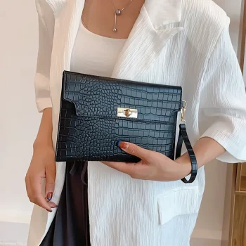 Woman holding a black stone pattern clutch bag with wristlet strap and secure clasp