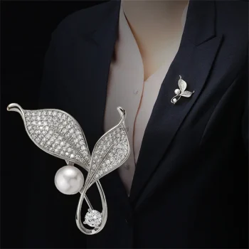 Elegant pearl leaf brooch with rhinestones pinned on blazer