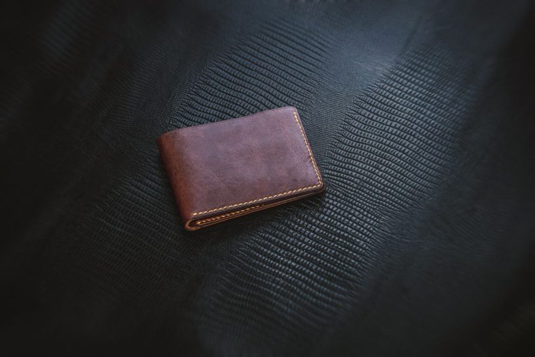Brown leather bifold wallet on a dark textured surface for everyday use